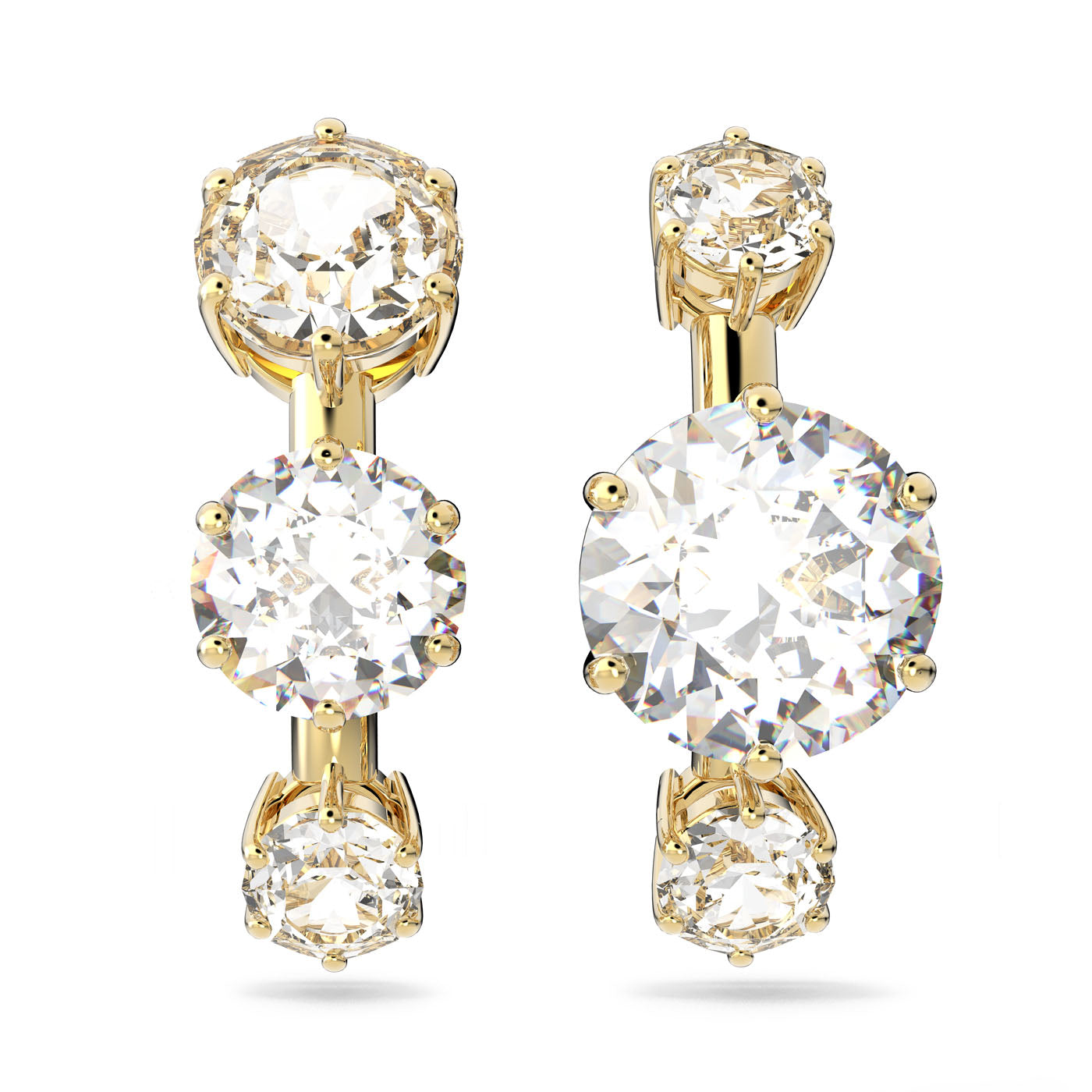 A set of exquisite Swarovski Constella ear cuffs, each adorned with three clear crystals set in gold-tone plated prongs. The crystals are arranged vertically, offering a luxurious and dazzling look.