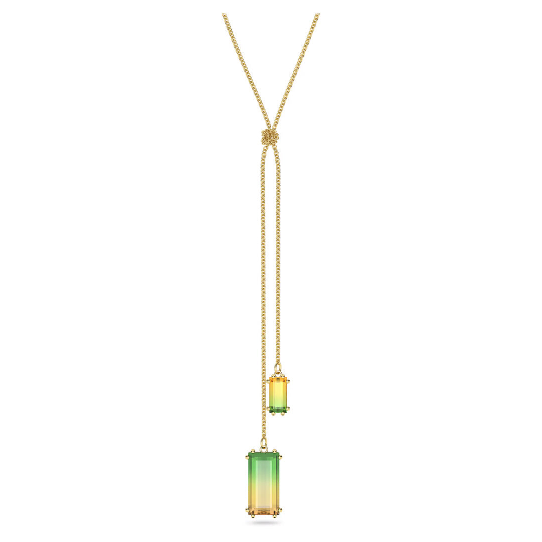 The Swarovski Millenia Y Necklace Pendant, designed by Swarovski, showcases a gold-tone plated chain adorned with two gradient pendants in green and yellow from the Millenia Family. These glossy, rectangular pendants hang at varied lengths to add a touch of elegance to any ensemble.