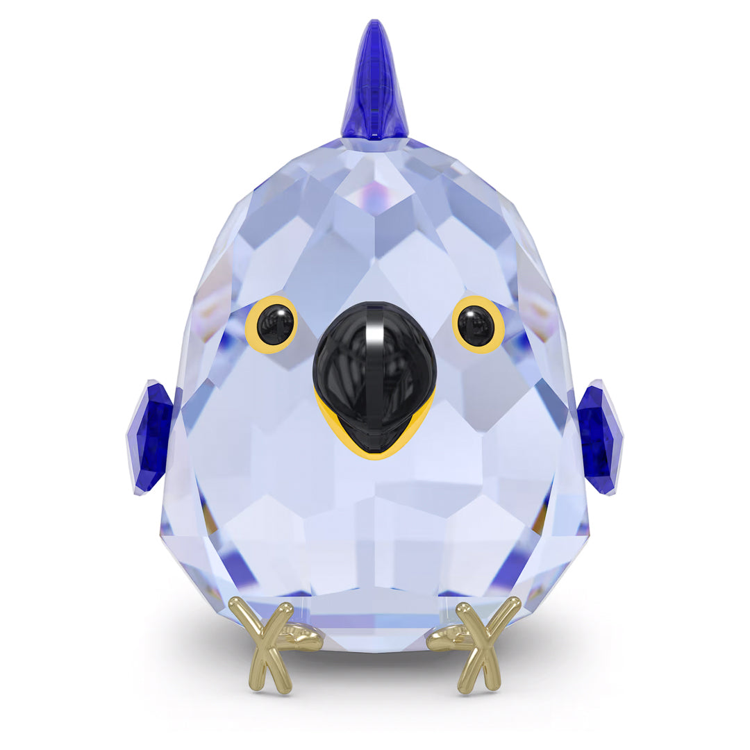 The Swarovski All you Need are Birds Blue Macaw Home Décor, by Swarovski, is a small and intricately designed crystal ornament featuring a faceted blue body, black eyes, and elegant gold accents on its beak and feet. With its cute round shape and pointed crest on its head, it's the perfect piece to add charm to your springtime decor.