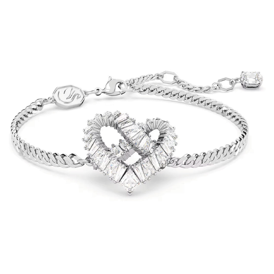 The Swarovski Matrix Bracelet by Swarovski is a stunning piece featuring a heart-shaped centerpiece embellished with baguette-cut clear crystals. It comes with a Cuban link chain and an adjustable clasp, finished off with a small square diamond charm, making it an ideal jewelry gift for someone special.