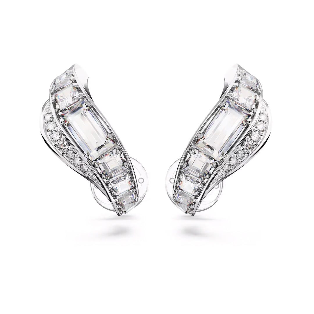 Close-up of stylish, silver-tone earrings from Swarovski, featuring the Hyperbola Clip Earrings design adorned with rectangular and round clear gemstones in a cascading wave pattern. The mixed-cut design glimmers under light, emphasizing the sophisticated and intricate details of the stones.