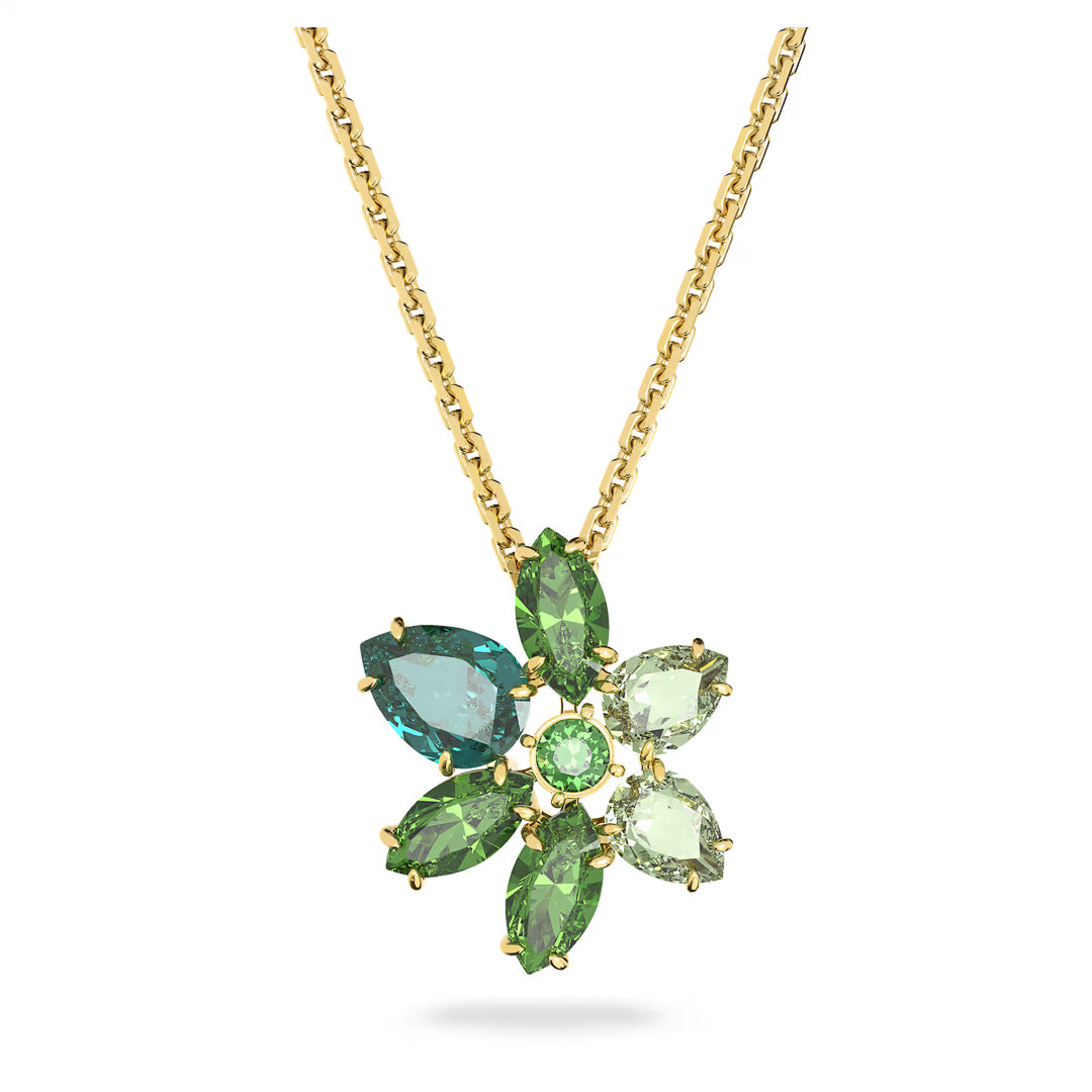 Explore the Swarovski Gema Necklace Pendant, a gold necklace designed with a floral motif showcasing five faceted green gemstones and a single turquoise gemstone arranged in a flower shape. Its simple gold link chain gracefully displays this stunning piece, capturing the vibrant hues of green and blue.