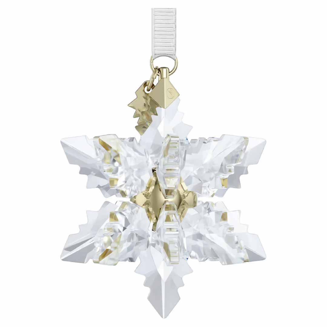 The Swarovski 2024 Annual Editions 3D Ornament from the renowned Swarovski brand, features an intricate crystal snowflake design with 3D facets and a gold-toned central accent, gracefully hanging from a thin, clear ribbon.
