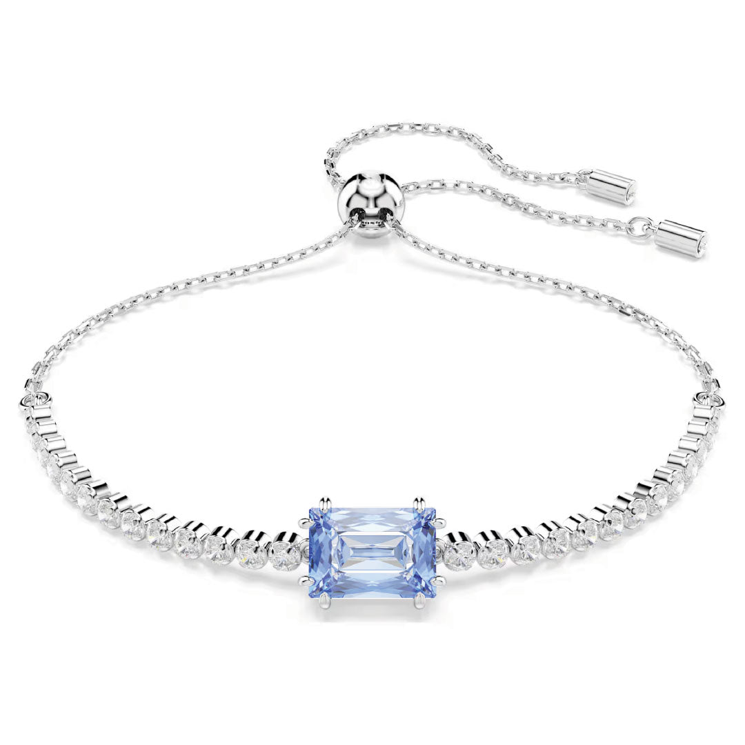 Introducing the Swarovski Matrix Tennis Bracelet by Swarovski, featuring a stunning central square-cut blue gemstone surrounded by radiant Swarovski Zirconia crystals. This elegant silver bracelet also includes a rhodium-plated chain with an adjustable slider closure for a perfectly tailored fit.