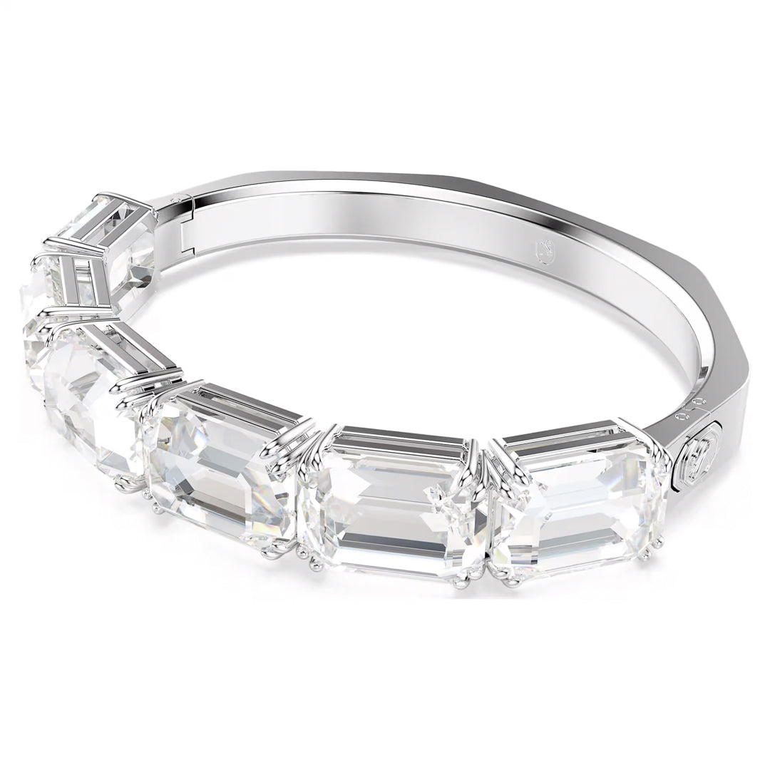 This elegant Swarovski Millenia Bangle showcases five large, rectangular clear gemstones arranged in a continuous row. Each octagon-cut crystal is secured with prong settings, and the bangle offers a sleek, polished finish.