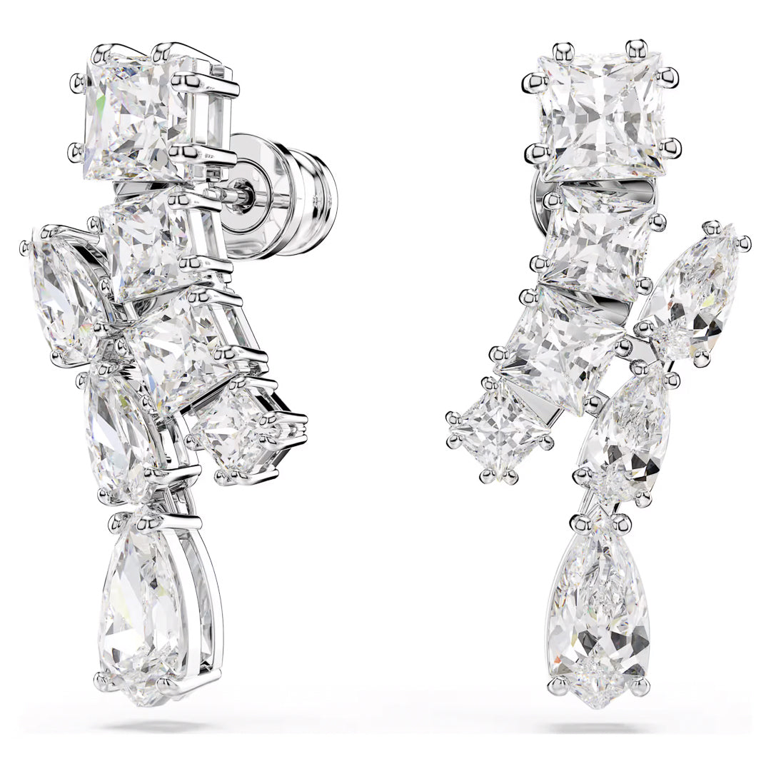 Introducing the Swarovski Matrix Drop Earrings, a pair of stylish asymmetrical earrings featuring a linear design with various cuts of dazzling Swarovski Zirconia. These gems, in square, oval, and teardrop shapes, are beautifully set in rhodium-plated silver to create a luxurious and intricate appearance.