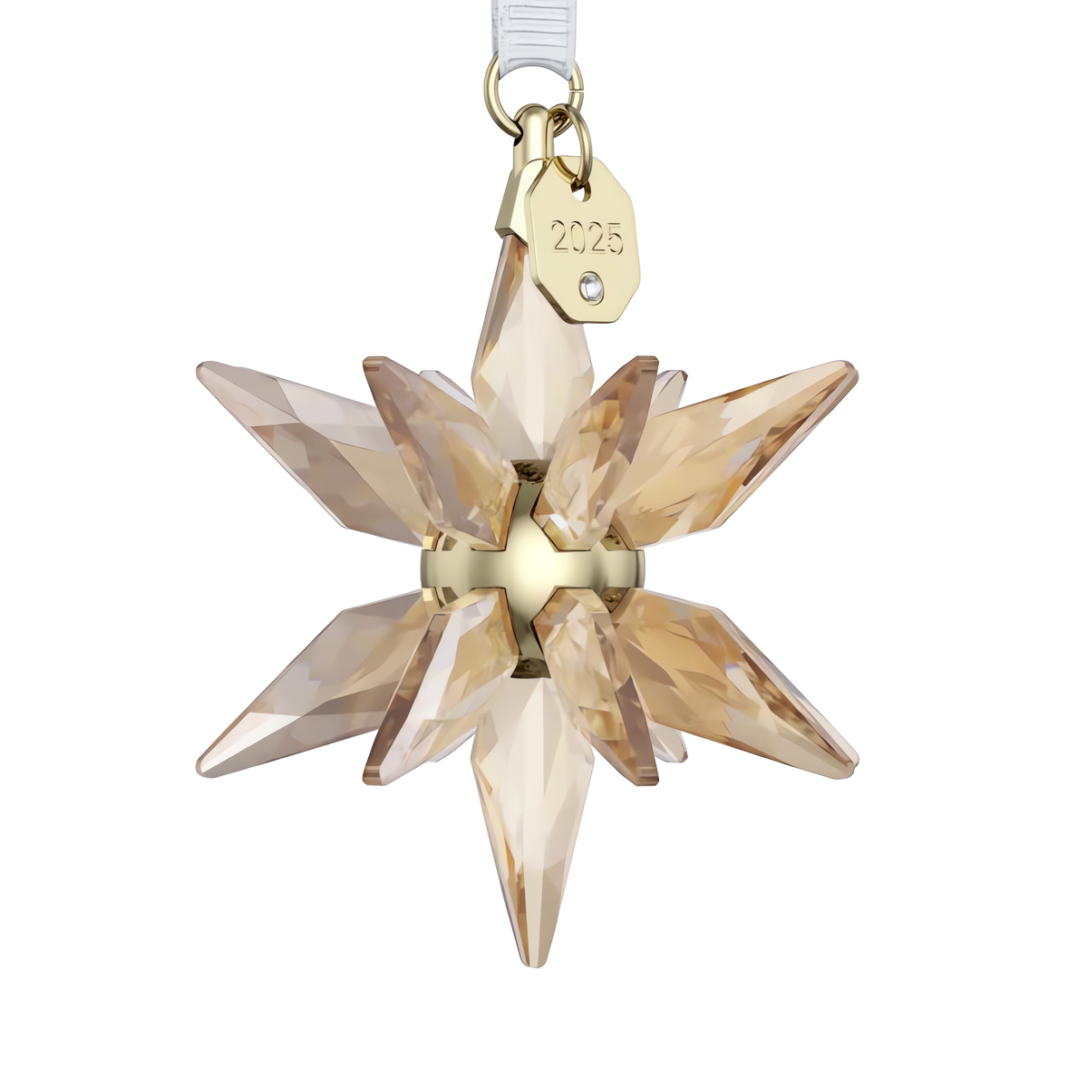 The Swarovski Annual Edition Festive 3D Ornament 2025 features a golden crystal star design with a small gold tag engraved with “2025,” suspended by a clear ribbon against a plain white background, embodying the timeless elegance characteristic of Swarovski.