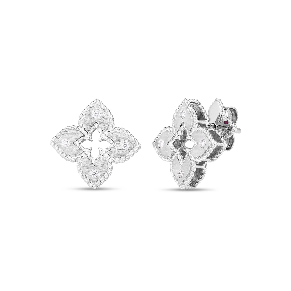 A pair of Roberto Coin Petite Venetian Princess 18K White Gold Diamond Accent Flower Stud Earrings designed in a four-petal floral shape with textured surfaces. Each earring showcases a central cut-out in a star-like pattern, highlighting the intricate detailing characteristic of Roberto Coin's elegant jewelry collection.