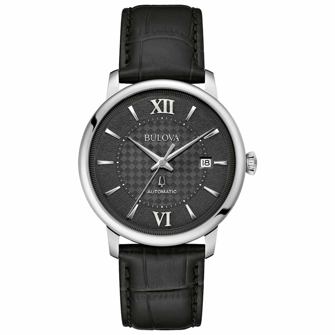 The Bulova Hudson Automatic 39mm Watch features a sophisticated black leather strap and a sleek silver case. Its round black dial is adorned with silver-tone hour markers and includes Roman numerals at the 12 and 6 positions, along with a date window at the 3 o'clock mark. The watch face is safeguarded by sapphire crystal, while the word "Automatic" is tastefully positioned just above the 6 o'clock spot.