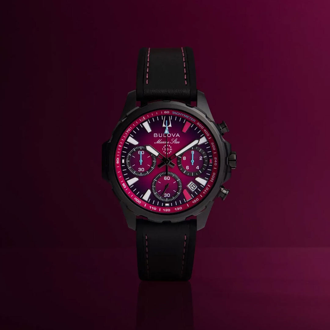 Introducing the Bulova Marine Star E1 Team Miami Quartz 41mm Watch—a striking men's timepiece by Bulova featuring a magenta dial with bold white hour markers and three subdials, complemented by a black leather strap. With its vivid dark red background, this eye-catching watch captures the dynamic style of Miami E1 Racing events, making it an ideal choice for electric boat racing enthusiasts.