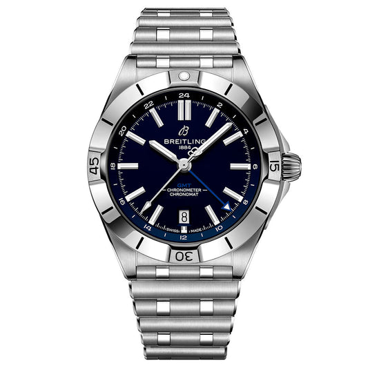 The BREITLING Chronomat Automatic GMT 40 is a stainless steel wristwatch with a dark blue dial, silver hour markers, date at 6 o’clock, metal link bracelet, engraved numeral bezel, and displays the time as 10:08.