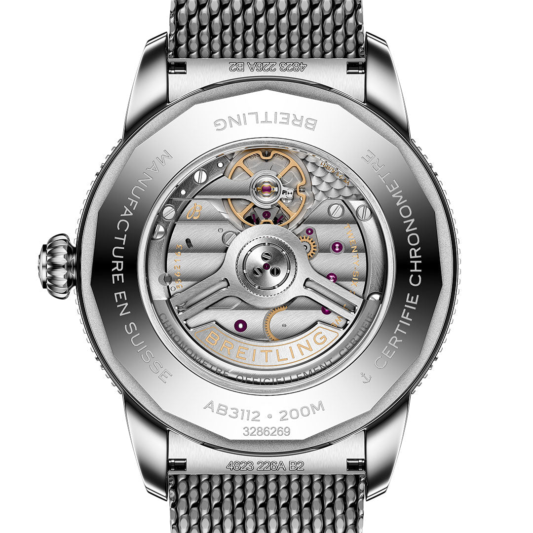 Close-up of the BREITLING Superocean Heritage B31 Automatic 44’s caseback, revealing its detailed automatic movement, visible gears, and engravings such as “MANUFACTURE EN SUISSE,” “CERTIFIE CHRONOMETRE,” and water resistance specs by Breitling.