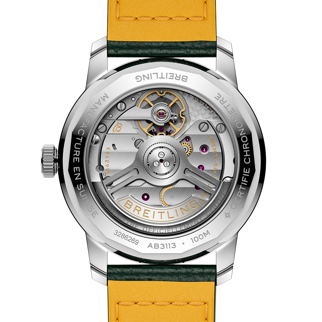 The back of the stainless steel BREITLING Top Time B31 38 highlights its intricate retro design with visible gears and jewels. A yellow leather strap with a green edge adds to its classic-car dashboard clock style, featuring distinctive Breitling B31 movement engravings.