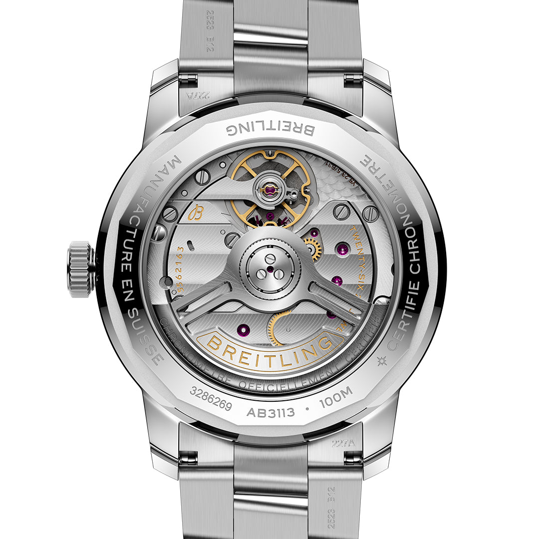 Close-up of a BREITLING Top Time B31 38 watch's back, showcasing the intricate Manufacture B31 movement and gears. The polished metal casing is engraved with "BREITLING" and "MANUFACTURE EN SUISSE." Visible screws and components highlight craftsmanship reminiscent of vintage racing gloves.