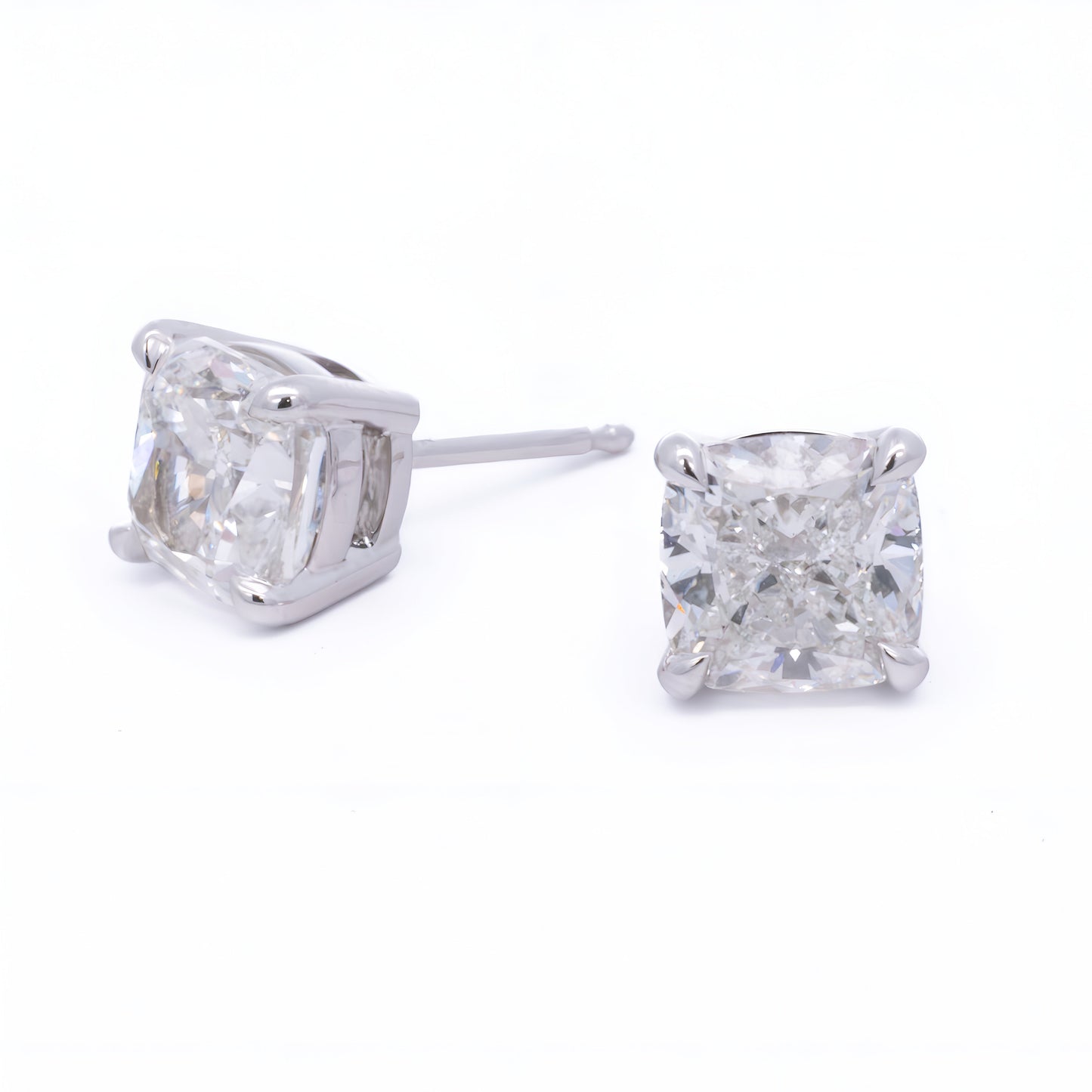 Close-up of a pair of Raffi&Co.® 14K White Gold Round Brilliant Lab Diamond Stud Earrings with large, round gemstones resembling diamonds in a simple prong setting that showcases the sparkling stones prominently.
