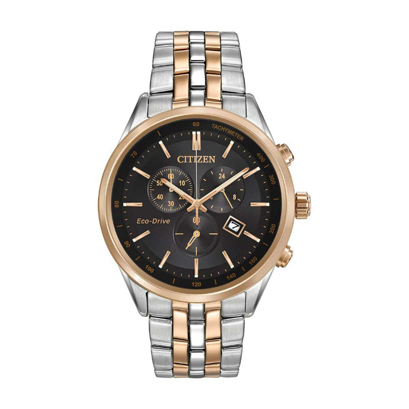 The CITIZEN Corso Eco-Drive 42mm Watch is a refined two-tone timepiece featuring a black dial with gold accents, protected by sapphire crystal. It includes a tachymeter, three subdials, and a date display, while the bracelet elegantly combines silver and gold links.