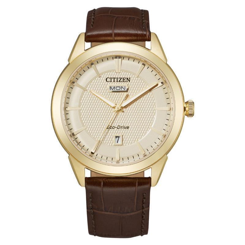 The CITIZEN Rolan Eco-Drive 40mm Watch by CITIZEN offers a vintage aesthetic with its gold-toned case and textured cream dial. It includes day and date displays, paired with a brown leather strap, capturing a clean, classic design enhanced by the innovative Eco-Drive technology.