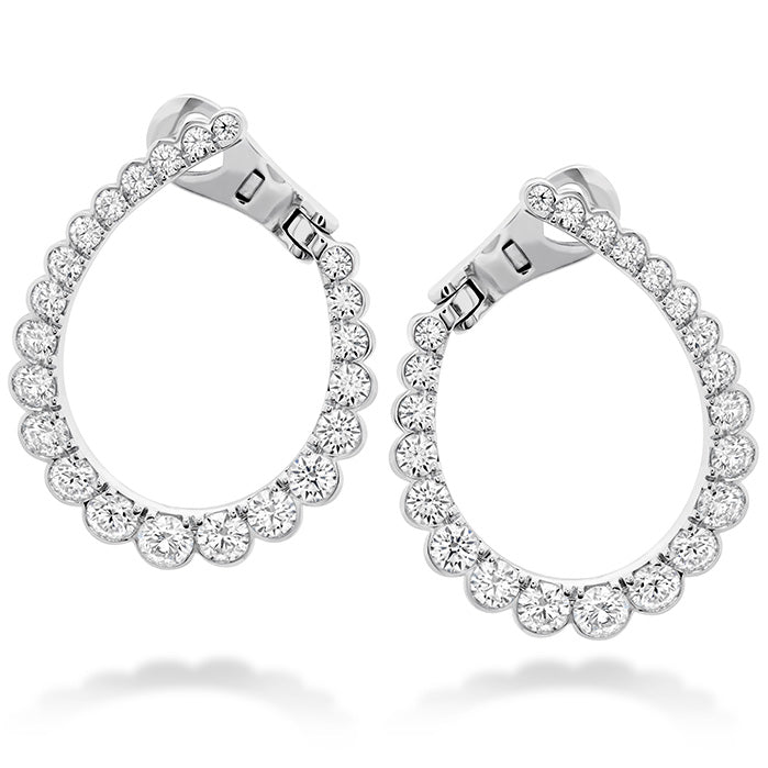 The Hearts On Fire Aerial Regal Hoop Earrings by Hearts on Fire are an elegant pair featuring a teardrop shape encrusted with sparkling round diamonds. Crafted in 18 Karat white gold, these earrings have a sophisticated hinge clasp design for easy wearing.