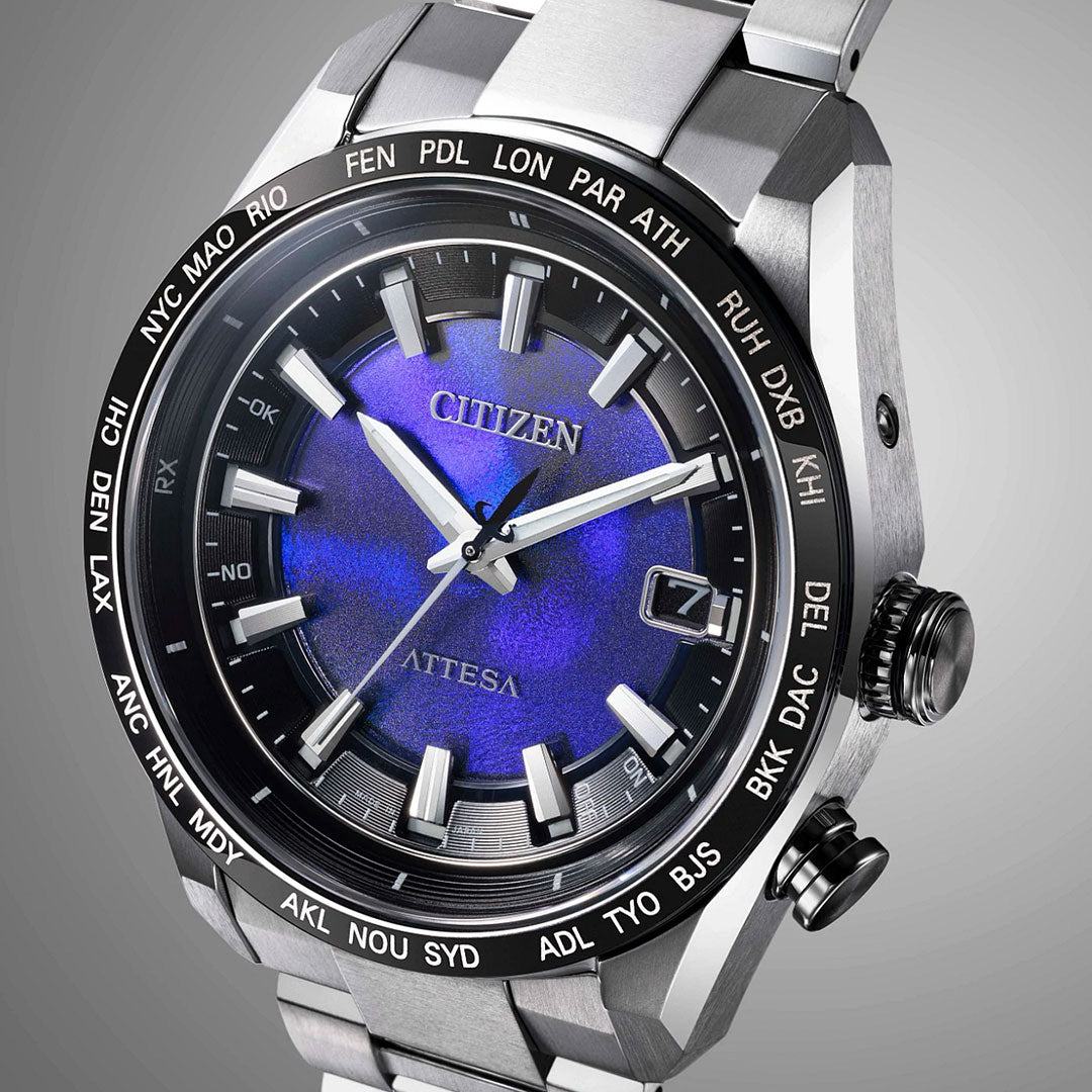 Close-up of the CITIZEN Attesa Hakuto-R Limited Edition Eco-Drive watch, featuring a 40.6mm Super Titanium case, metallic silver band, deep blue gradient dial with silver markers and date display, and a black bezel showing major world cities in white.