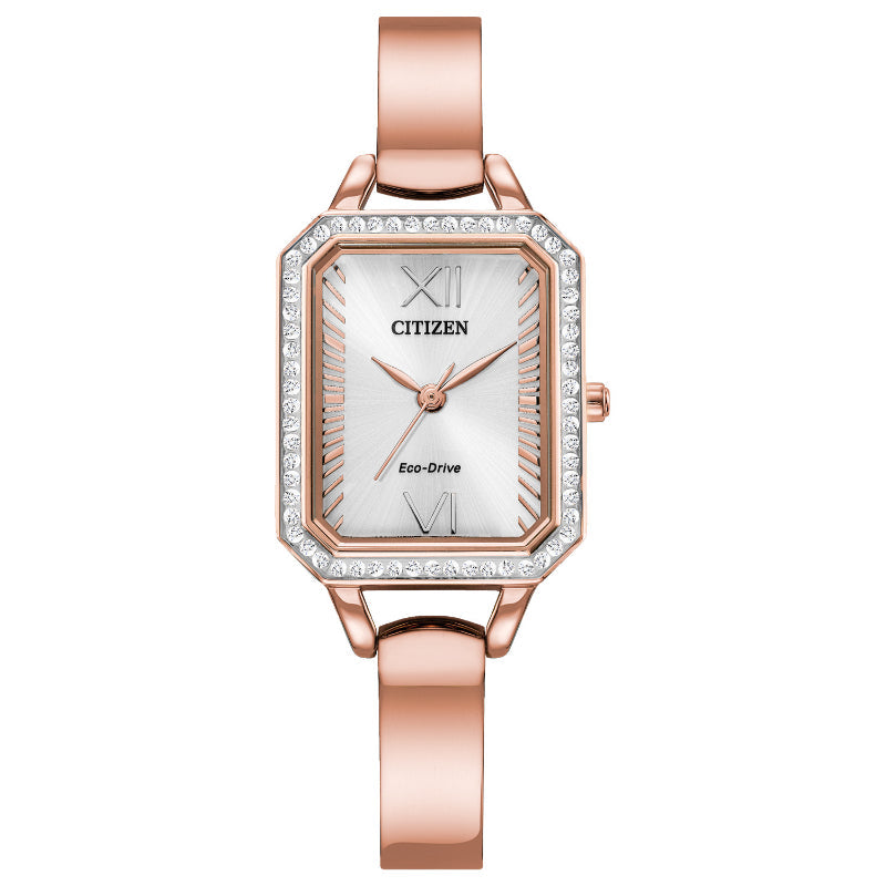 The CITIZEN Silhouette Crystal Eco-Drive 23mm Watch in rose gold showcases a rectangular face adorned with a diamond-studded bezel. Accentuated by Roman numerals at the 12 and 6 o'clock positions, it features Eco-Drive technology and a sleek, slender pink gold-tone bracelet.