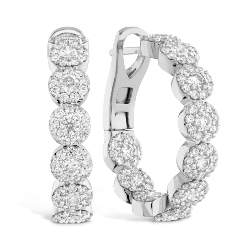 Explore the irresistible charm of Hearts on Fire with these luxurious jewelry pieces: the exquisite Hearts On Fire Fulfillment Hoop Earrings. These elegant earrings feature sparkling diamonds set in radiant white metal. One earring presents a front-facing look, highlighting its circular design, while the other offers a side view that accentuates the clasp.