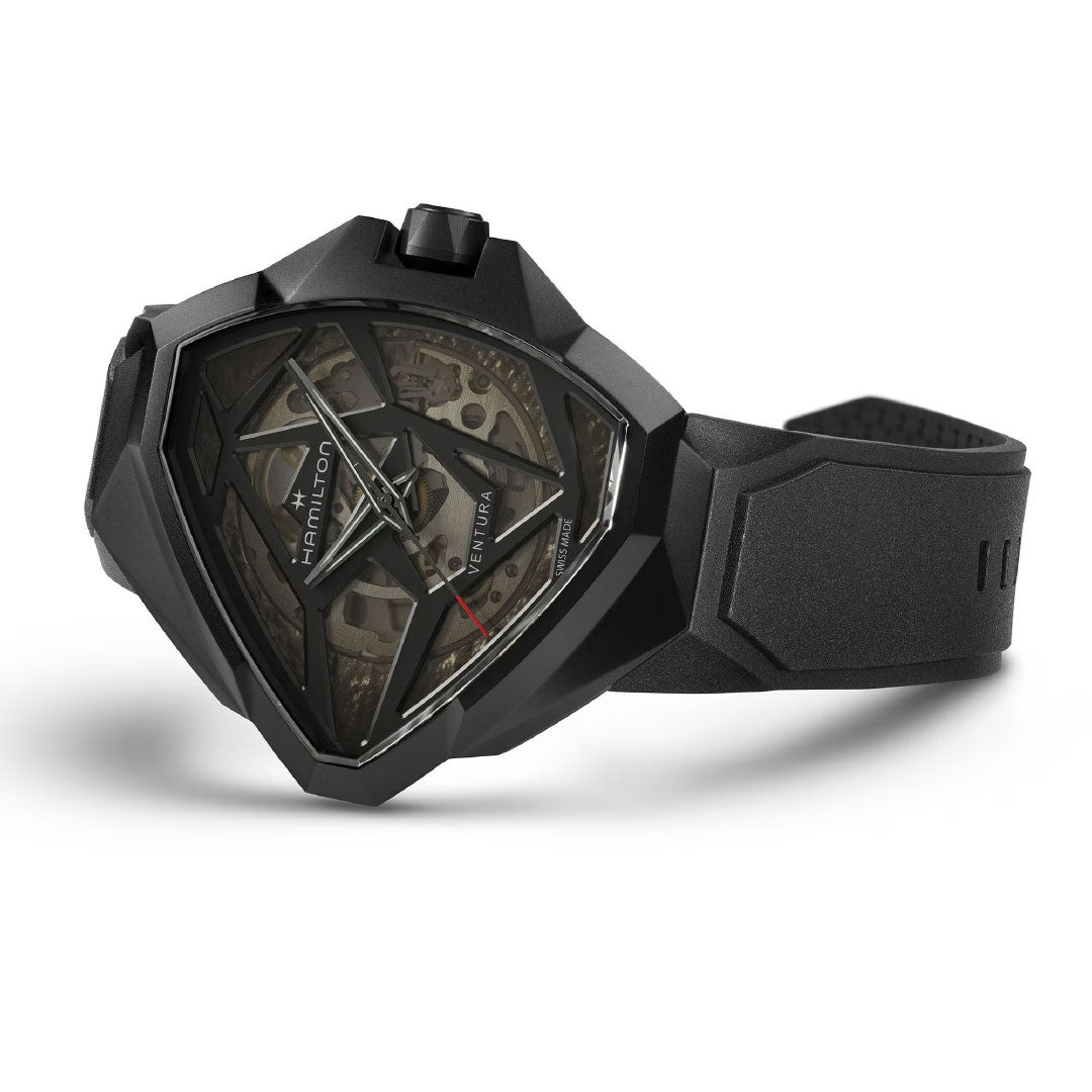 The Hamilton Ventura Edge Skeleton Automatic 51mm x 47mm watch by Hamilton Watch features a black triangular case, skeletonized dial showing inner gears, and a black rubber strap, shown against a white background.