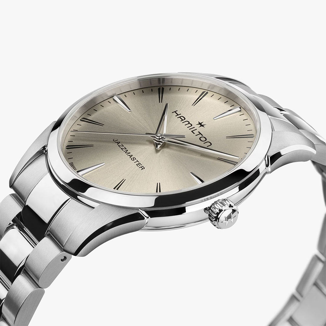 A close-up of the Hamilton Watch Jazzmaster Quartz 40mm with a stainless steel band and metallic off-white dial, showcasing minimalist hour markers and hands.