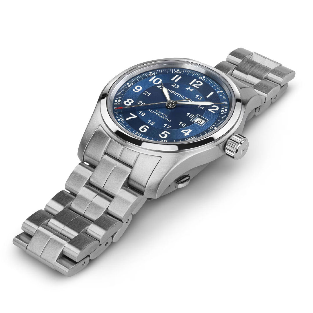 The Hamilton Khaki Field Auto 42mm stainless steel wristwatch features a blue dial with white numerals, date display, and a metal link bracelet, showcased on a white background and reflecting its military heritage design.