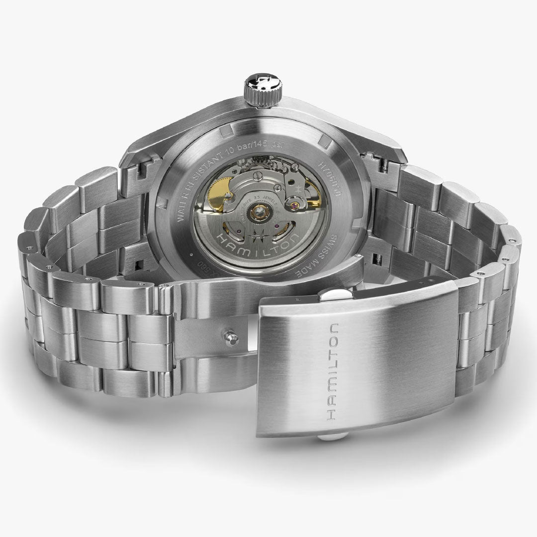 A close-up of the back of the Hamilton Khaki Field Auto 42mm Watch by Hamilton Watch, featuring an open metal bracelet and showcasing its automatic movement and engraved case back details.