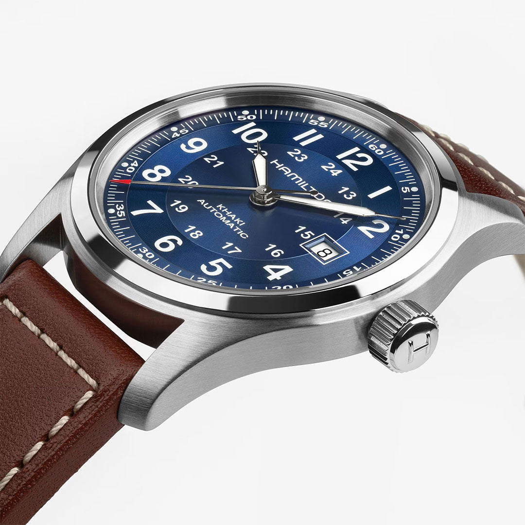 A close-up of the Hamilton Khaki Field Auto 42mm by Hamilton Watch, featuring a blue dial with white numerals, date window, stainless steel case, and brown leather strap—reflecting its military roots and reliable automatic movement.