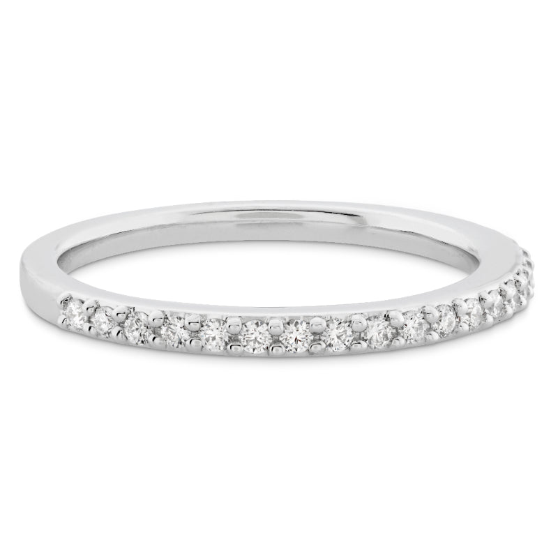 Introducing the Hearts On Fire Camilla 18K White Gold Round Brilliant Diamond Anniversary Ring, a sleek and sophisticated piece crafted by Hearts on Fire. This ring features small, sparkling diamonds set along the top half, embodying a classic and minimalist design. Perfect for celebrating anniversaries, it is beautifully displayed against a white background to accentuate its shine and exquisite craftsmanship.