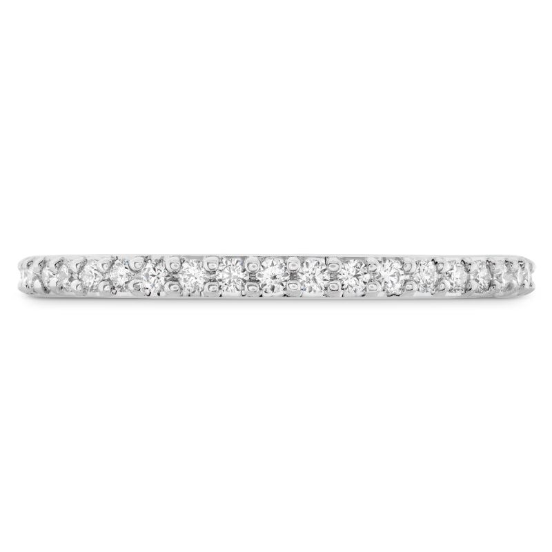 A close-up of the Hearts On Fire Camilla 18K White Gold Round Brilliant Diamond Anniversary Ring reveals its elegant design, featuring a continuous row of sparkling round diamonds set on a smooth, shiny band of 18 Karat white gold. The diamonds create a glittering effect across the entire length, reminiscent of an exquisite anniversary bracelet.