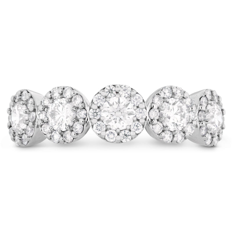 Five Hearts On Fire Fulfillment 18K White Gold Round Brilliant Diamond Anniversary Rings are arranged side by side. Each ring showcases a stunning central diamond encircled by smaller diamonds, all set in a sleek 18K white gold band. The design emphasizes the sparkling brilliance of this luxury collection from Hearts on Fire.