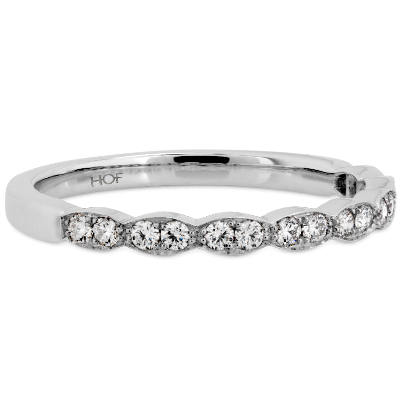The Hearts On Fire Lorelei Floral Anniversary Ring boasts a polished 18 Karat White Gold finish, adorned with round brilliant diamonds elegantly arranged in a simple row across the top. Its minimalist design is beautifully highlighted on a plain white background.