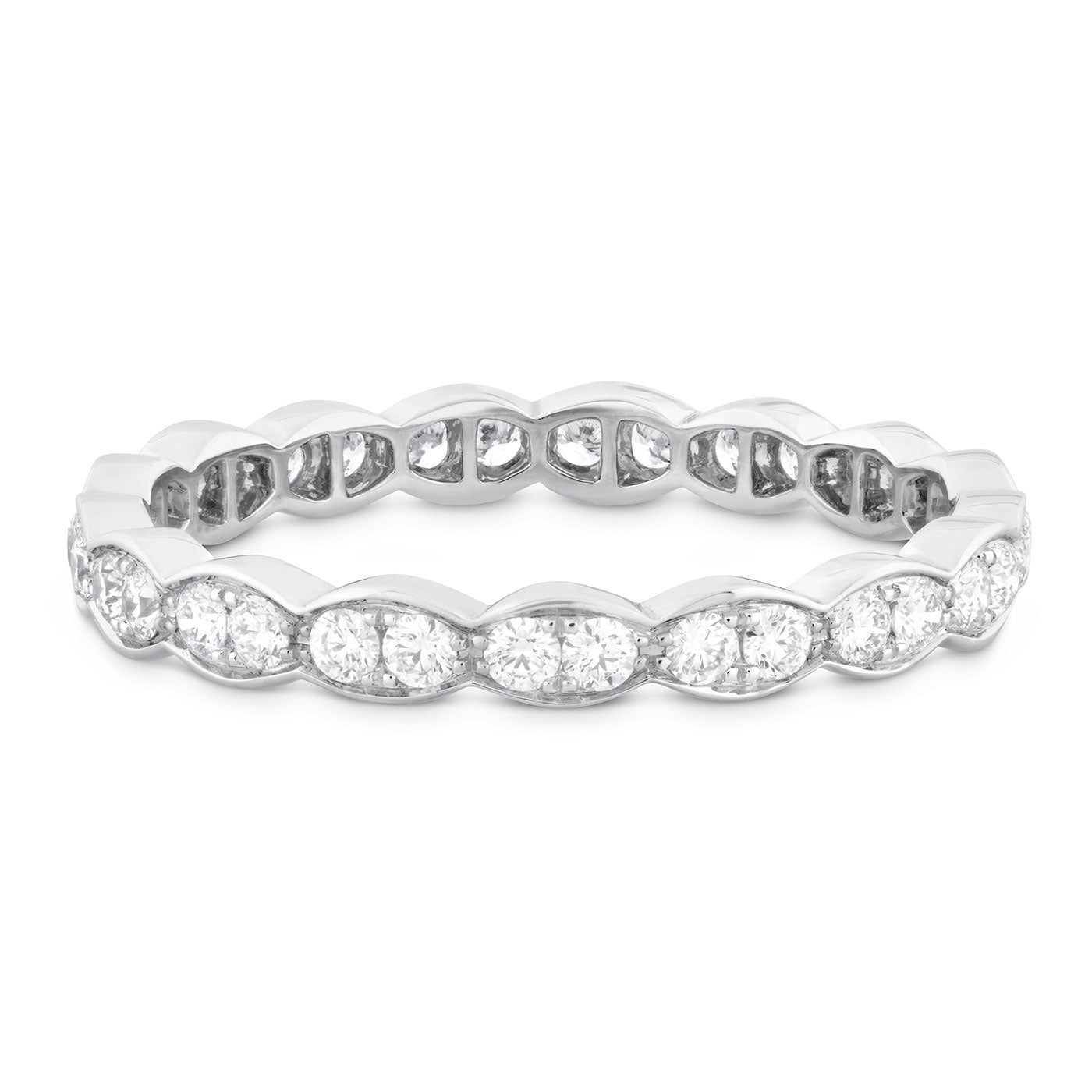 The Hearts On Fire Lorelei Floral 18K White Gold Round Brilliant Diamond Eternity Ring showcases a stunning circle of round brilliant diamonds that envelop the entire band, forming an elegant and seamless design. Crafted by Hearts on Fire, these diamonds are set in a scalloped bezel, enhancing the ring's refined style.