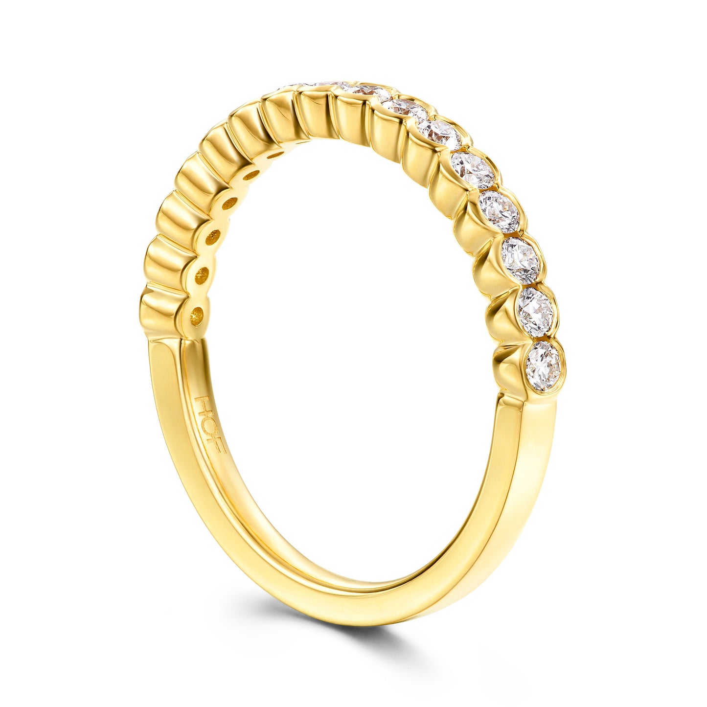 The Hearts On Fire Isabelle 18K Yellow Gold Bezel Round Brilliant Diamond Anniversary Ring showcases a series of round, clear diamonds elegantly set along the top half. Its smooth finish and subtly ridged design enhance its elegance, offering a perfect choice for those seeking timeless beauty.