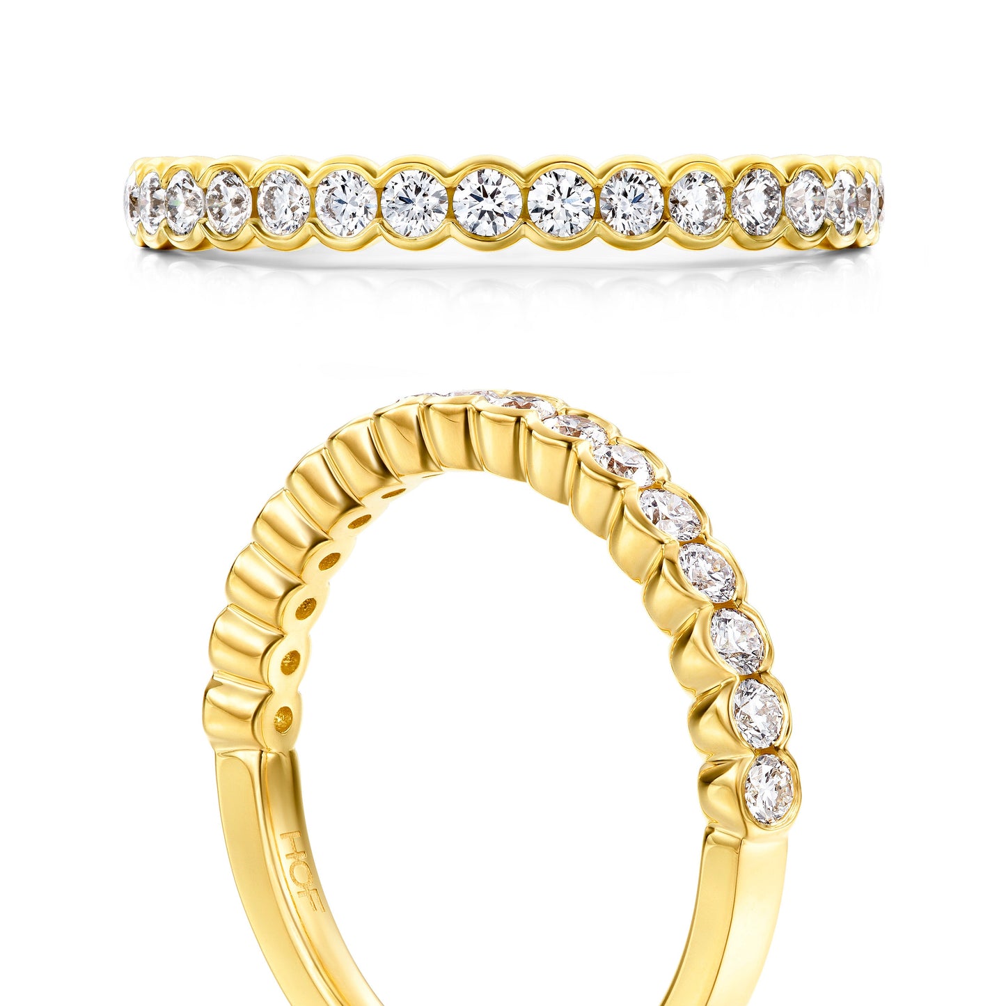 The Hearts On Fire Isabelle 18K Yellow Gold Bezel Round Brilliant Diamond Anniversary Ring boasts a row of round, sparkling diamonds. The top view reveals the complete circle of stones, while the angled side view emphasizes the intricate setting and band detail, creating a beautifully classic allure from Hearts on Fire.