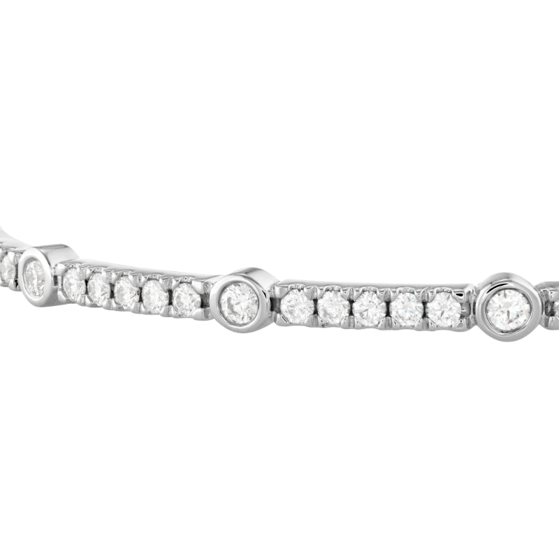 A close-up of the Hearts On Fire Copley Bangle, masterfully crafted in 18 Karat Rose Gold by Hearts on Fire and adorned with small, round-cut diamonds set in a seamless line. The gemstones are evenly spaced, enhancing the elegance of the jewelry, framed perfectly against a white background.