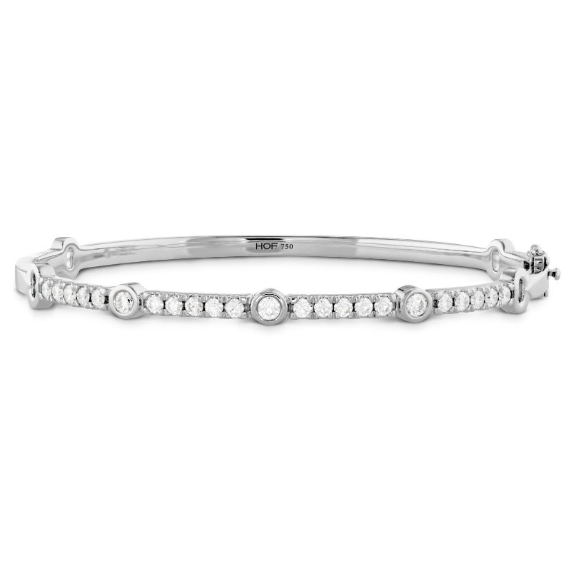 The Hearts On Fire Copley Bangle is a sophisticated piece crafted in 18 Karat Rose Gold. It features small circular diamonds and is beautifully highlighted with larger round diamond accents evenly spaced along its length, presenting a delicate and luxurious look.