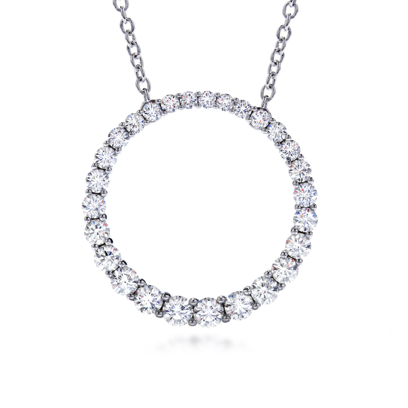 This Hearts on Fire Whimsical 18K White Gold Pendant is displayed on a silver chain, featuring a circle made entirely of sparkling round diamonds. The pendant elegantly connects to the chain, offering a minimalist yet luxurious design.