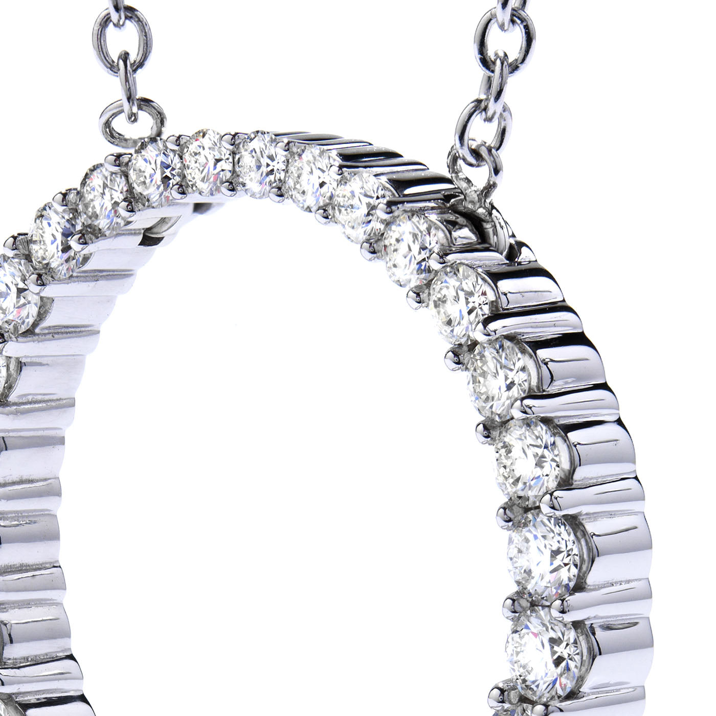Close-up of the Hearts On Fire Whimsical 18K White Gold Pendant, featuring a circular design adorned with sparkling round diamonds and attached to a chain on both sides. The focus highlights the intricate detailing and shimmering quality of the stones, creating an enchanting effect synonymous with Hearts on Fire.