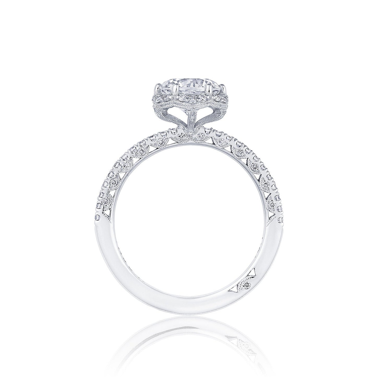 Discover the Tacori Petite Crescent 18K White Gold Round Brilliant Semi Mount Engagement Ring, featuring a stunning round diamond accented by a halo of smaller diamonds. This exquisite ring is complemented by an intricately detailed pave-set diamond band, expertly designed by Tacori to stand upright and showcase its breathtaking craftsmanship.