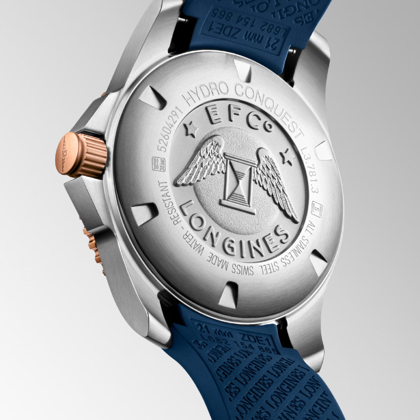 Close-up of the Longines HydroConquest Automatic 41mm Watch's stainless steel case back, showcasing an engraved logo with wings and an hourglass. The text includes "HYDRO CONQUEST," "LONGINES," along with other specifications. The watch is complemented by a blue strap and features a rose gold crown.