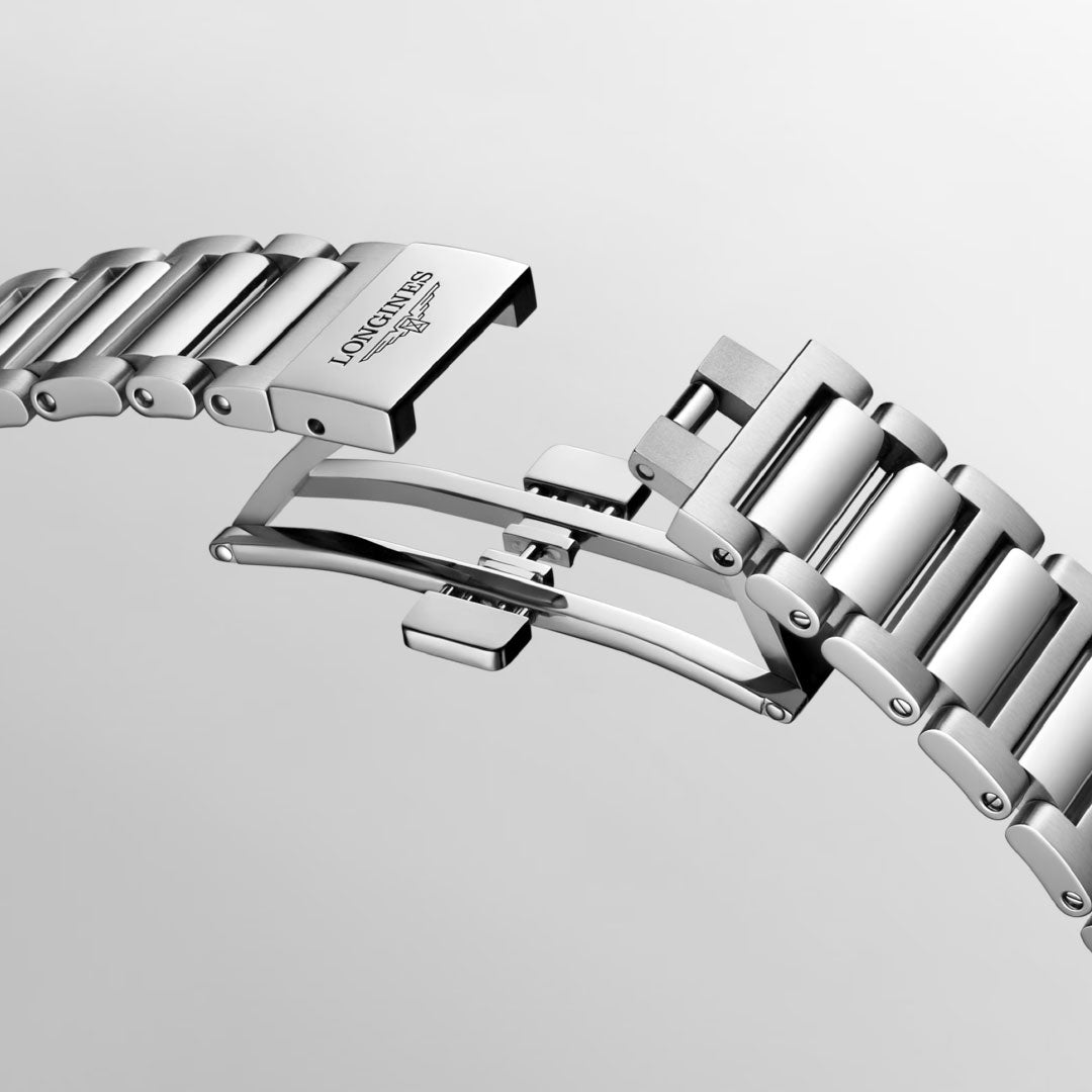 A silver metal bracelet from the Longines Conquest Automatic 42mm Watch exudes elegance with its visible interlocking clasp mechanism. It prominently features the "LONGINES" engraving near the clasp, embodying the spirit of Conquest. The bracelet appears open against a plain, light background.