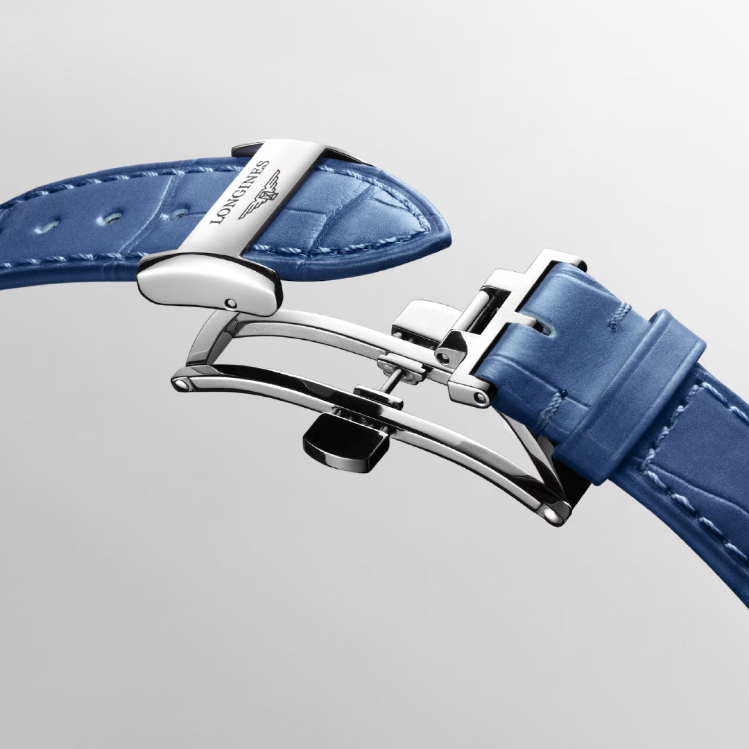 Close-up of the Longines Primaluna Moonphase Automatic 34mm Watch: features a blue leather strap and stainless steel clasp, from Longines, displayed on a plain light gray background.