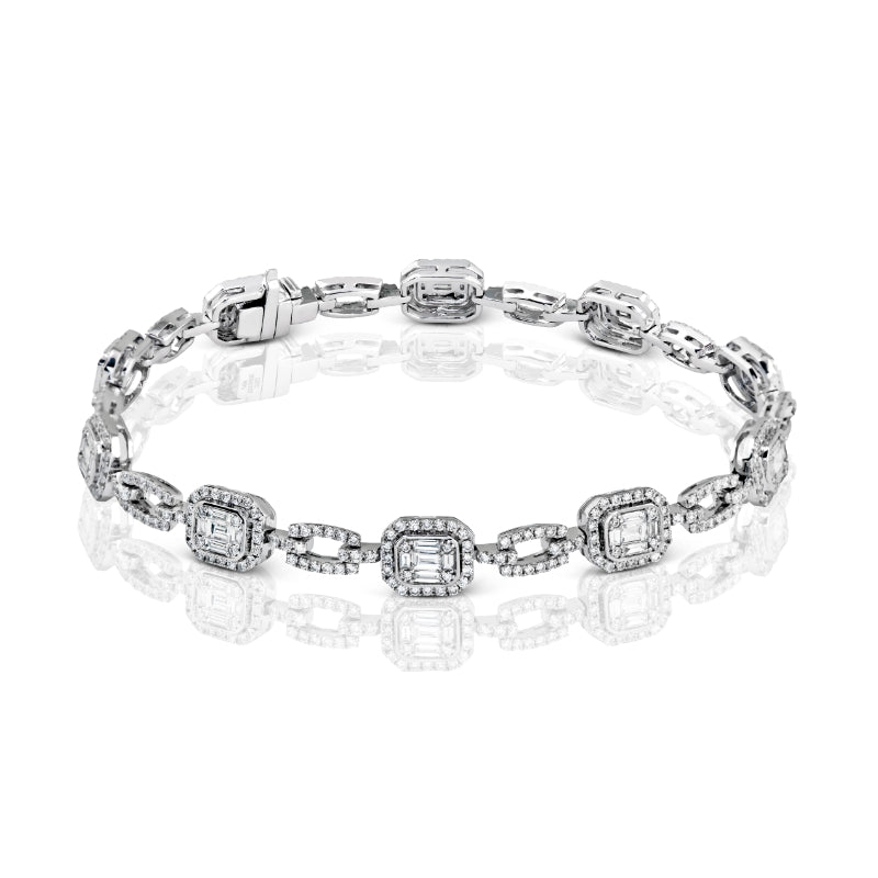 The Simon G. 18K White Gold Diamond Bracelet features rectangular links adorned with baguette and round diamonds in a geometric pattern, surrounded by smaller stones, shown on a reflective white background.