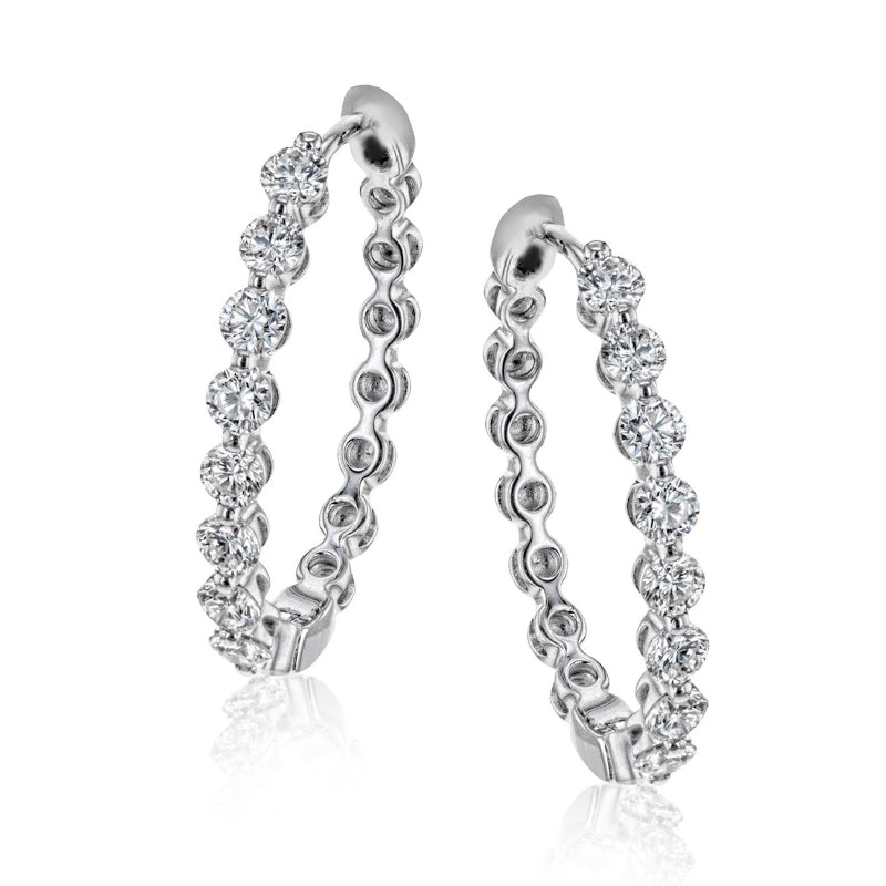 The Simon G. 18K White Gold Diamond Hoop Earrings exude elegance as they are embellished with shimmering white diamonds, thoughtfully arranged along the hoop. This design offers a luxurious and refined look, ideal for sophisticated occasions, all set against a plain white background.