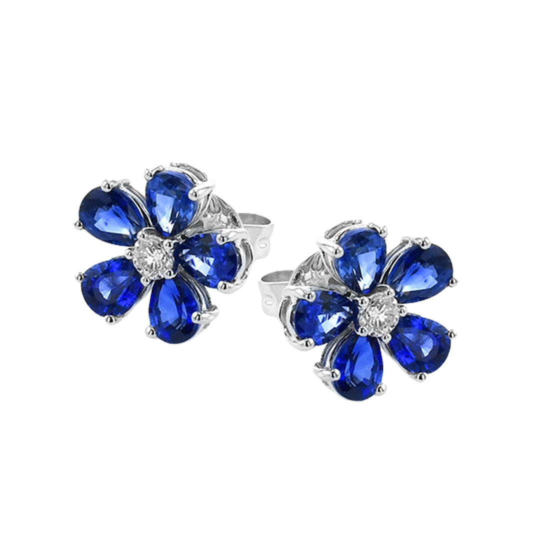 Simon G's 18K white gold stud earrings feature flower-shaped designs with blue pear sapphires as petals and a round diamond center.