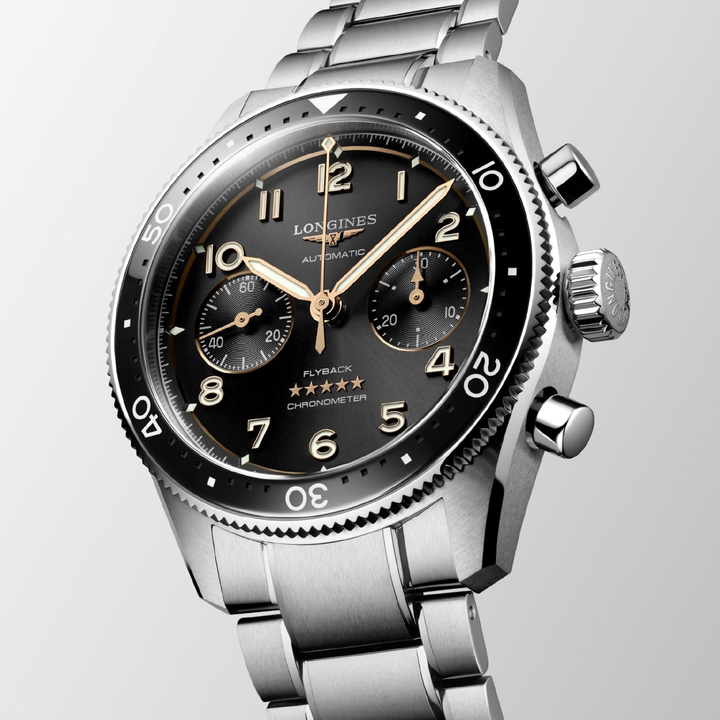 This close-up highlights the Longines Spirit Flyback Automatic Chronograph 42mm Watch, featuring a stainless steel case with a black dial adorned with Arabic numerals, three subdials, and a bezel with minute markings. The timepiece is complemented by a polished silver bracelet and prominent side push-buttons, epitomizing Longines' legacy as legendary pioneers in watchmaking.