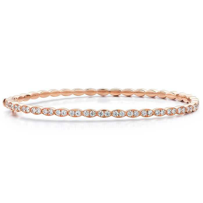 Introducing the Hearts On Fire Lorelei Floral Bangle Bracelet, an exquisite 18 Karat Rose Gold creation from Hearts on Fire. This delicate piece features small embedded diamonds forming a continuous loop, making it perfect for achieving an elegant and understated look.